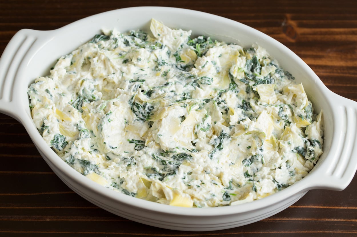 Spreading Spinach Artichoke Dip mixture into small casserole dish.