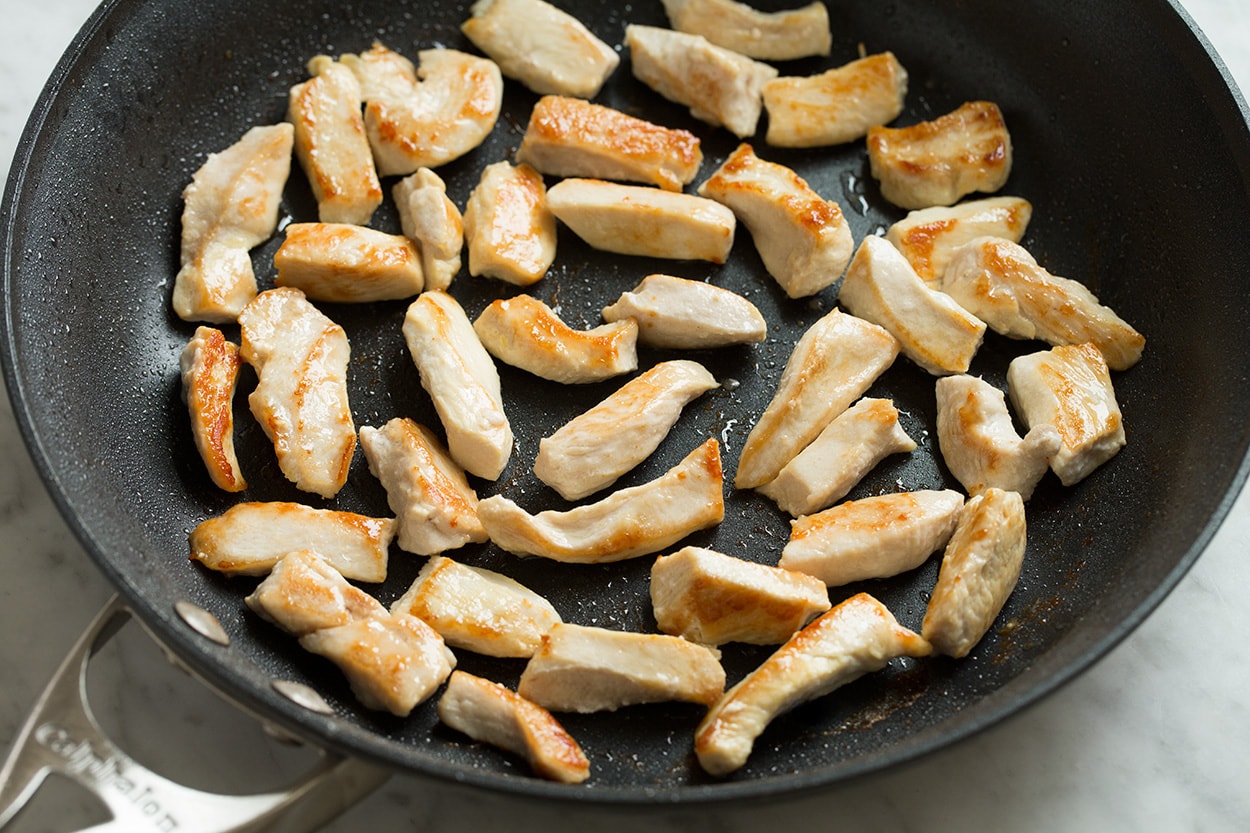 Searing pieces chicken in skillet for chow mein.