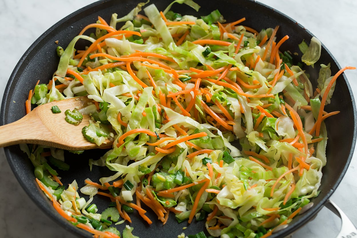 Sauteeing vegetables in a skillet for chow mein.