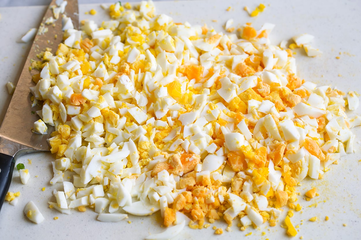 Egg Salad Chopping eggs on a cutting board into small pieces
