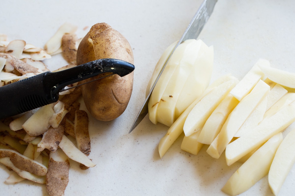 Baked French Fries Showing how to prepare potatoes for french fries, peeling potatoes and slicing into sticks.