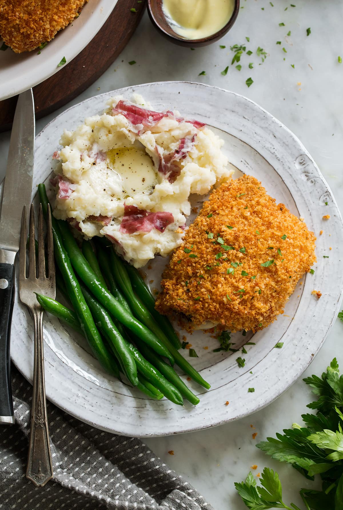 Oven Fried Chicken on serving plate with a side of mashed potatoes and green beans.