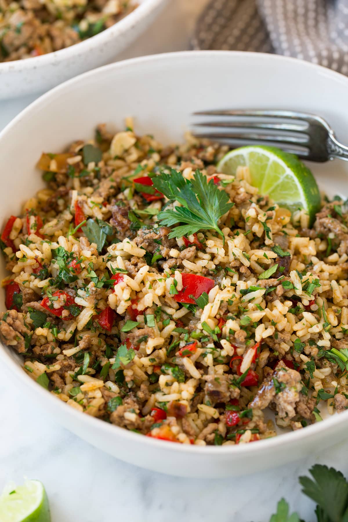 Chimichurri Beef and Rice in a white serving bowl set over a marble surface.