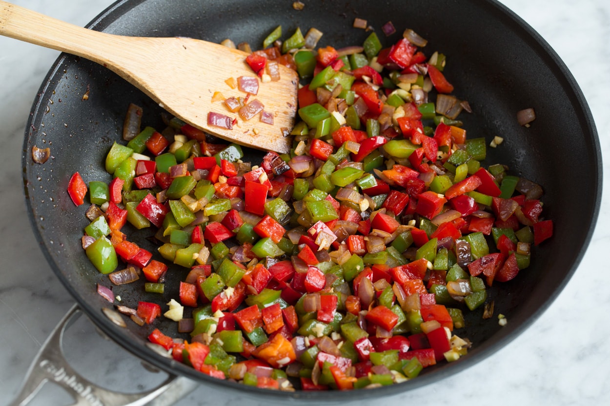 Sauteing bell peppers and onions in skillet to use as a filling for quesadillas.