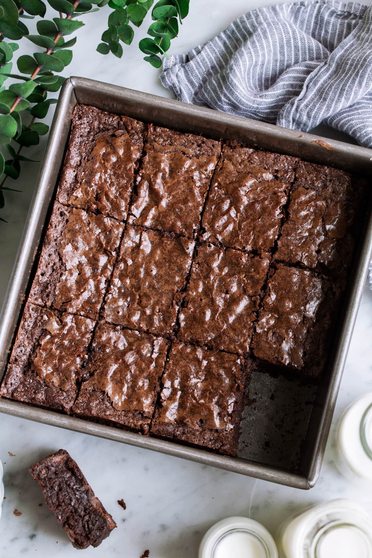 Overhead image of cut brownie squares in a square baking dish.