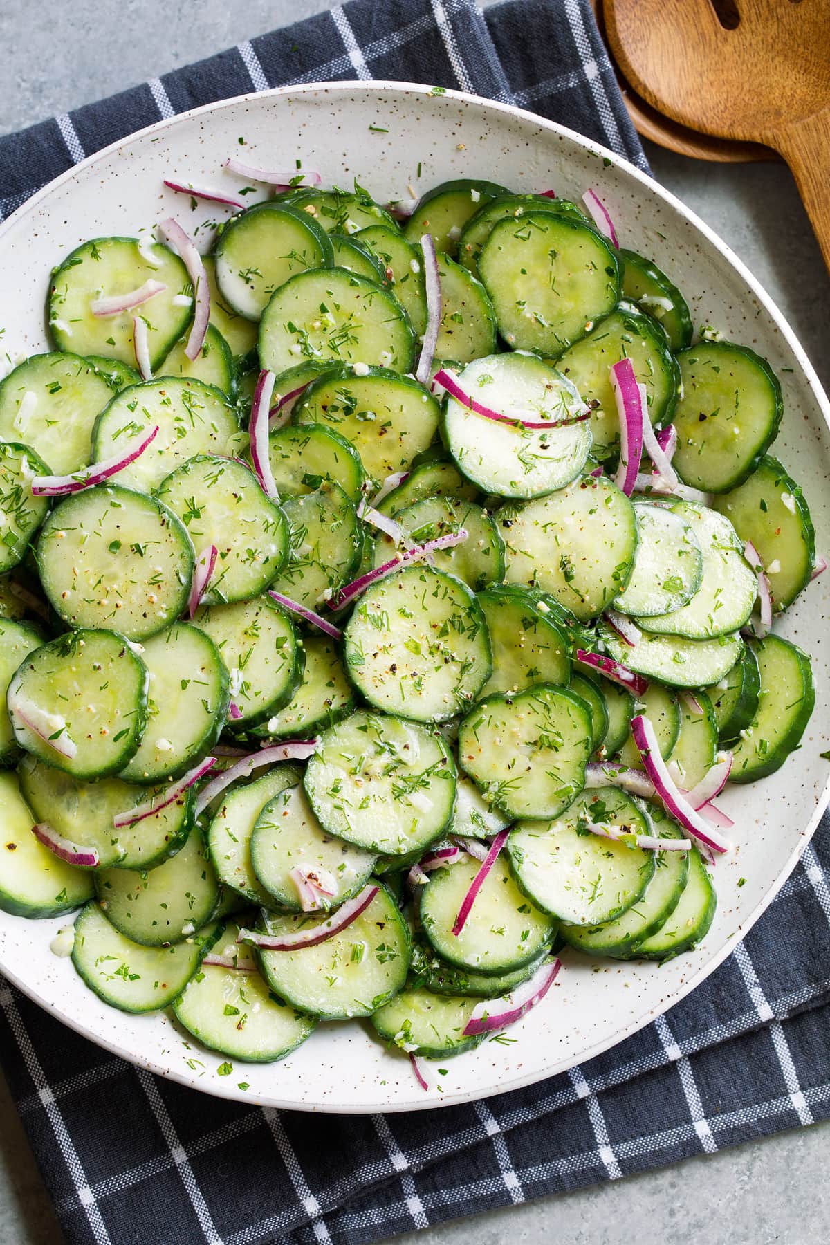 Cucumber Salad in white serving bowl set over a dark grey napkin.