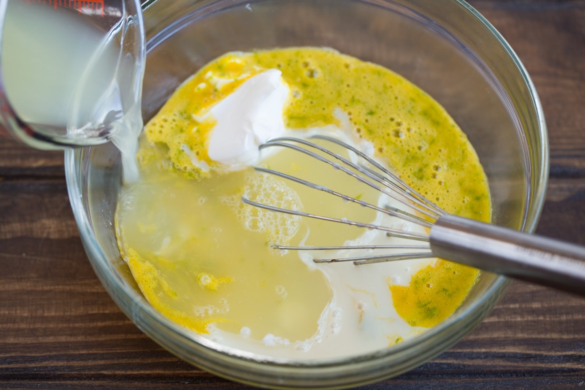 Adding lime juice and sweetened condensed milk to key lime pie filling mixture.