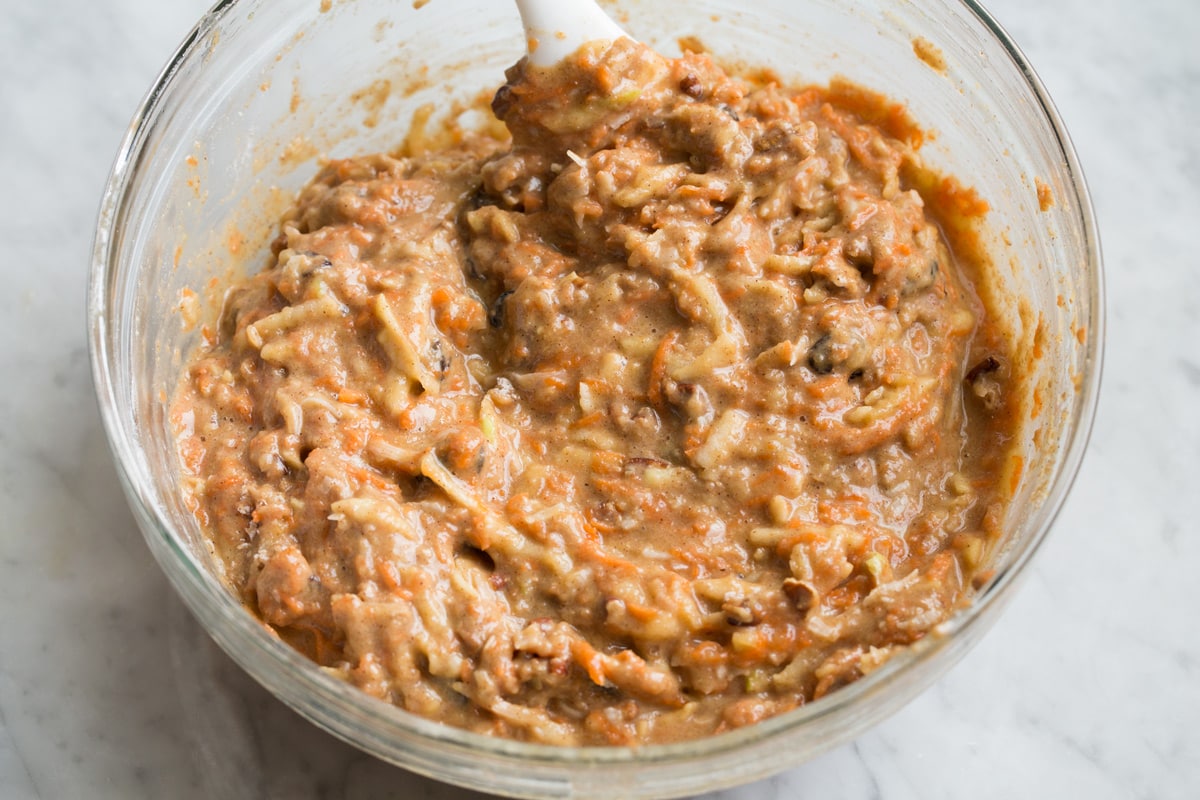 Finished morning glory muffin batter in a glass mixing bowl.