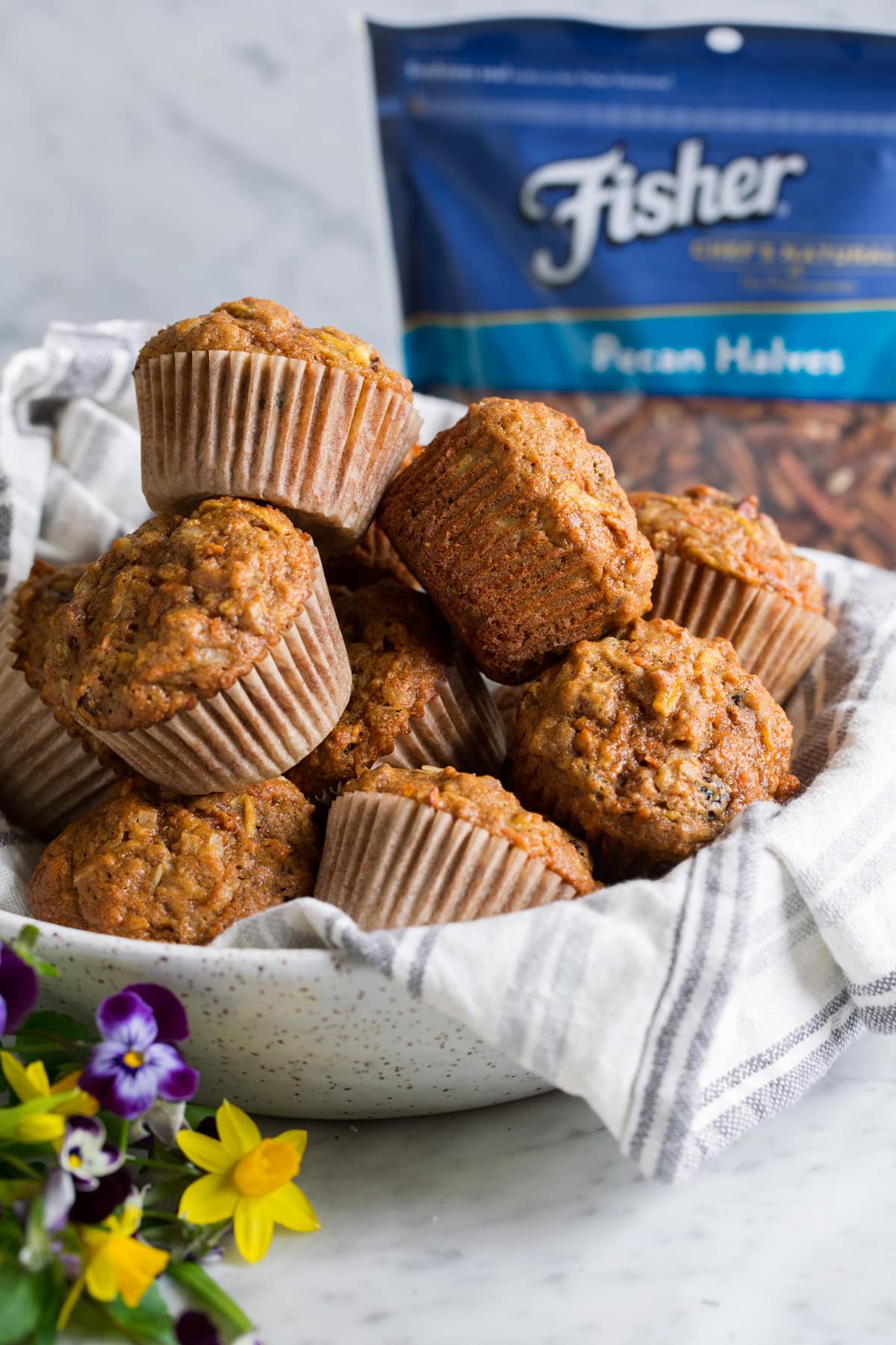 Morning glory muffins stacked in a speckled ceramic serving bowl
