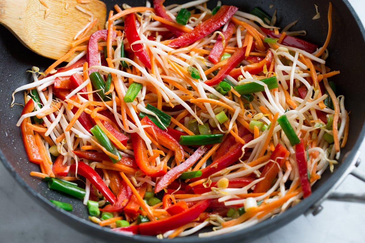 Sautéing vegetables in wok for pad thai.