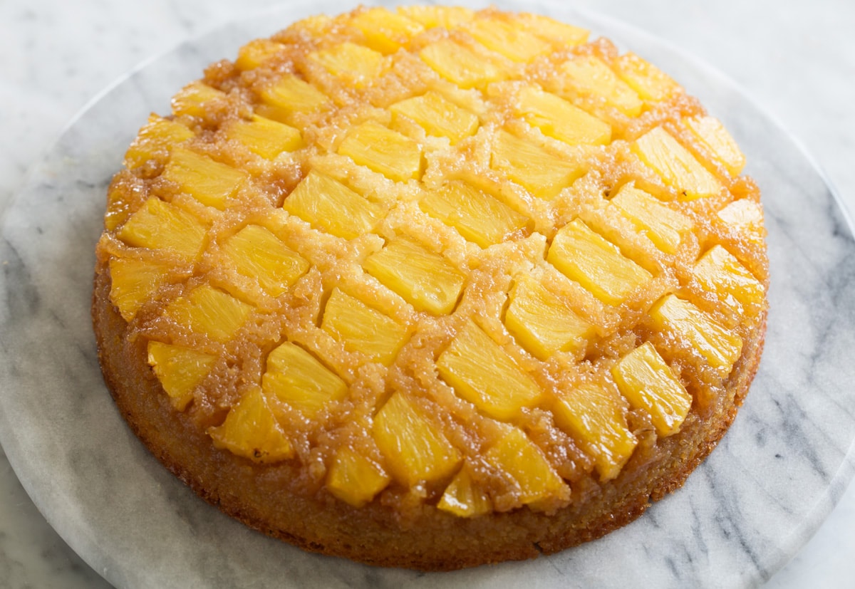 Whole Pineapple Upside Down Cake shown after baking and inverting onto marble platter. 