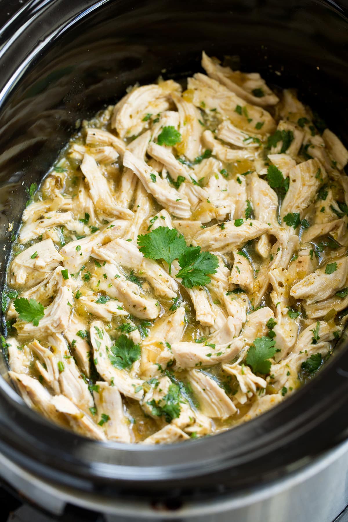 Salsa Verde Chicken Tacos (Slow Cooker or Instant Pot) Shredded salsa verde chicken garnished with cilantro.