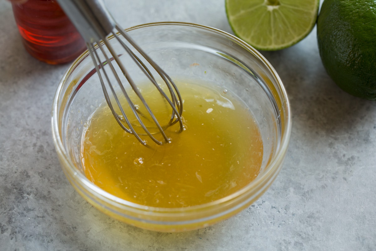 Shrimp with Honey Lime Sauce (Only 5 Ingredients!) Showing how to make shrimp with sauce. Whisking together honey and lime in a glass mixing bowl.
