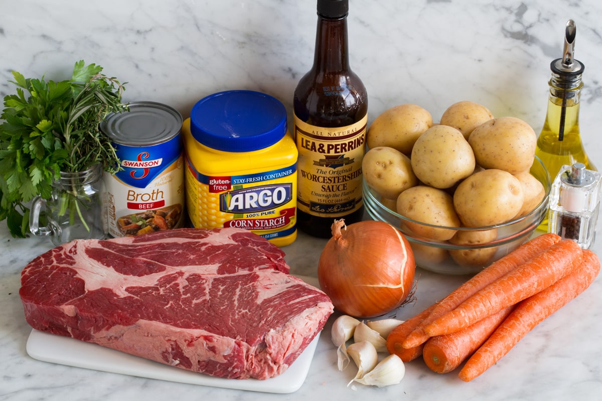 Ultimate Slow Cooker Pot Roast Ingredients needed for crockpot pot roast including chuck roast, yellow potatoes, carrots, onion, garlic, herbs, Worcestershire, beef broth, garlic, and cornstarch.