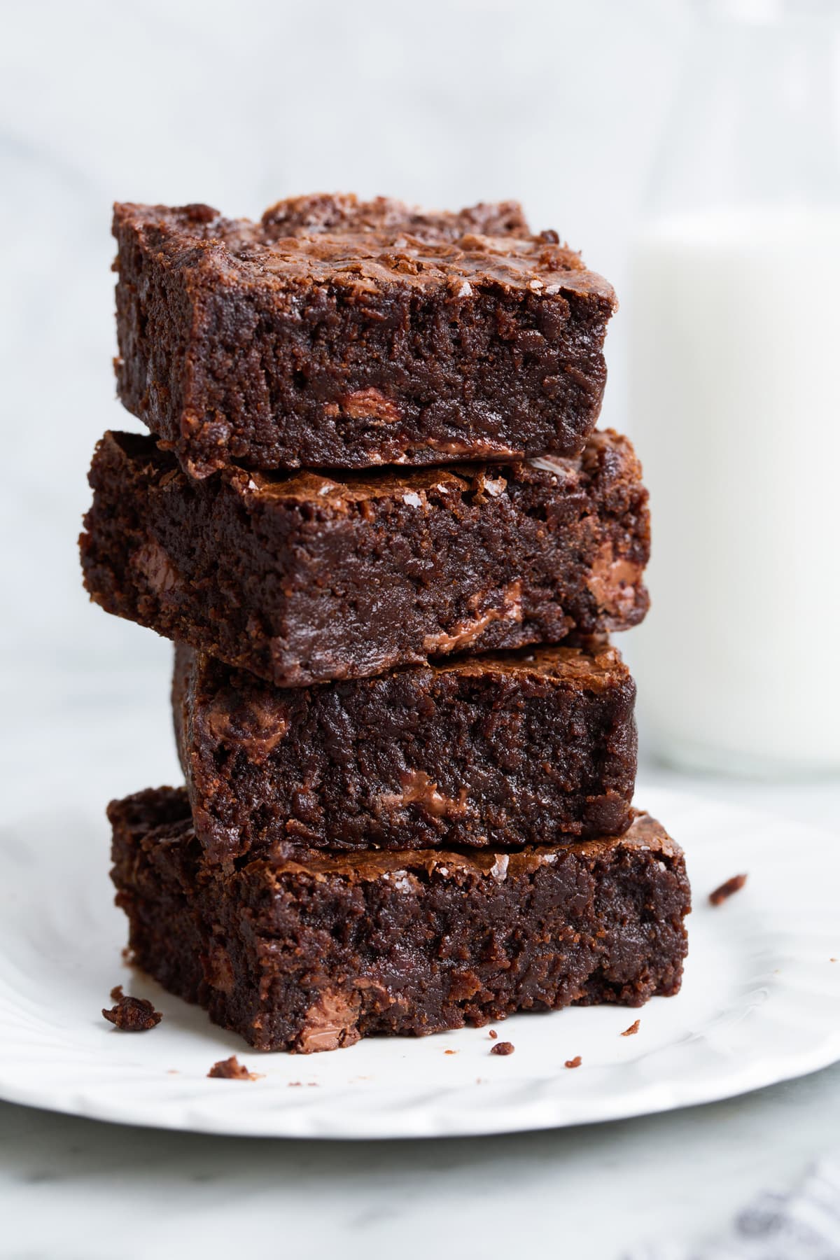 Stack of brownies on a white dessert plate.