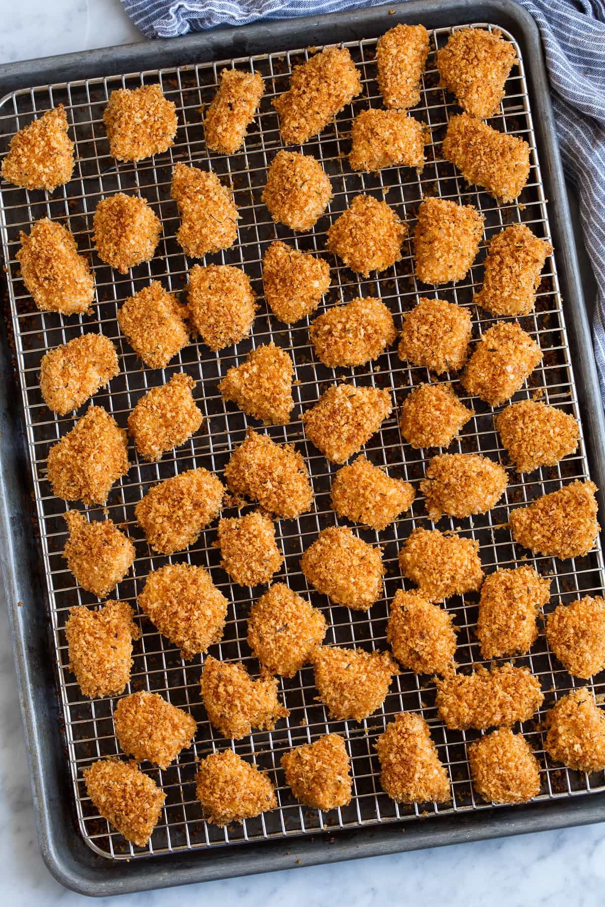 Chicken Nuggets shown on wire rack over baking sheet after baking.