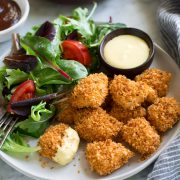 Chicken Nuggets on a serving plate with a side salad.