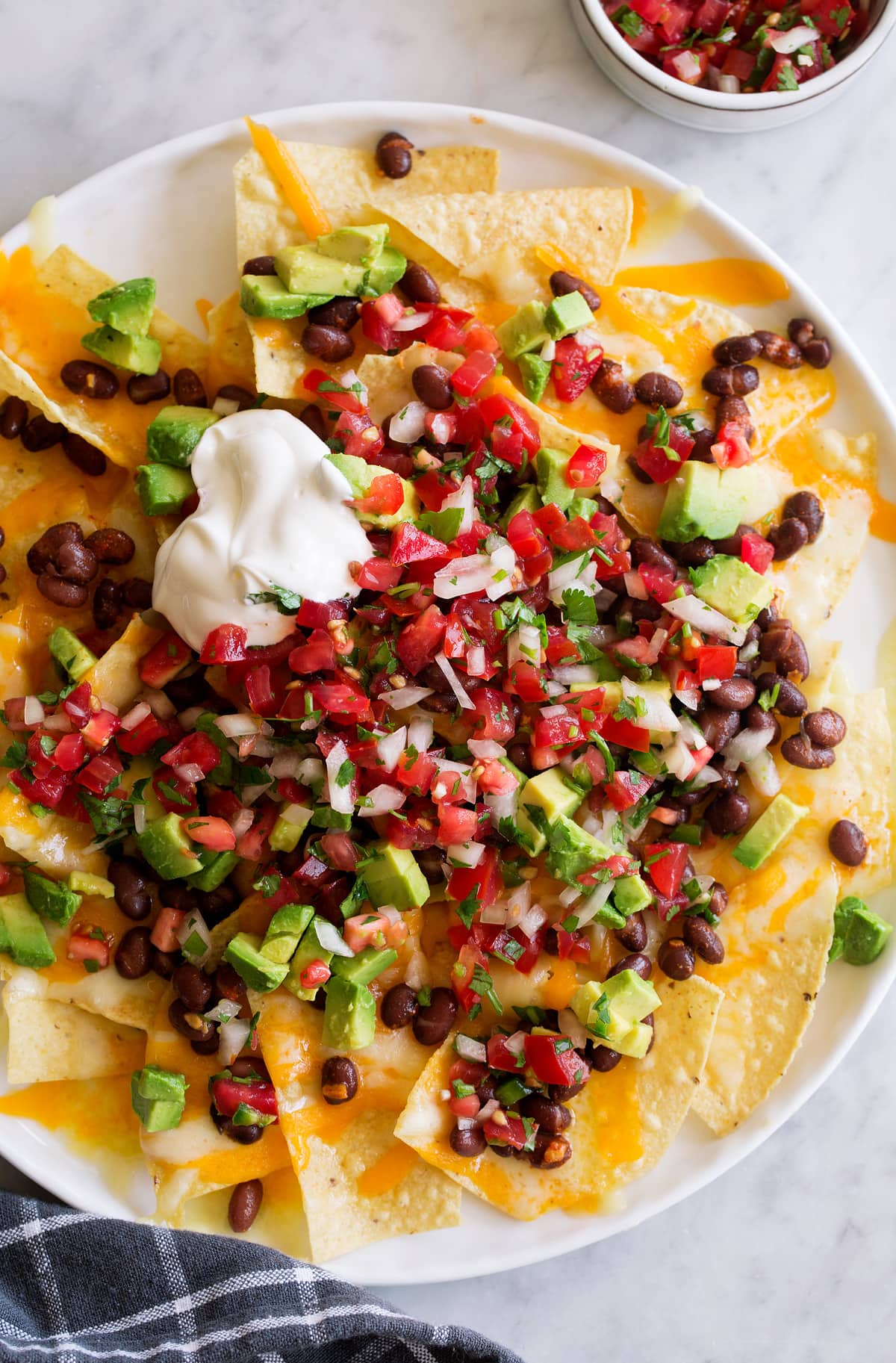 Fresh Pico de Gallo Recipe! Pico de gallo over nachos along with melted cheddar, black beans, diced avocado and sour cream.