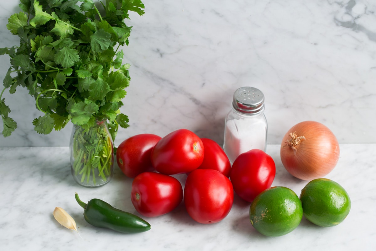 Easy Pico de Gallo! Pico de gallo ingredients: tomatoes, lime, yellow onion, jalapeno, garlic, salt and cilantro.