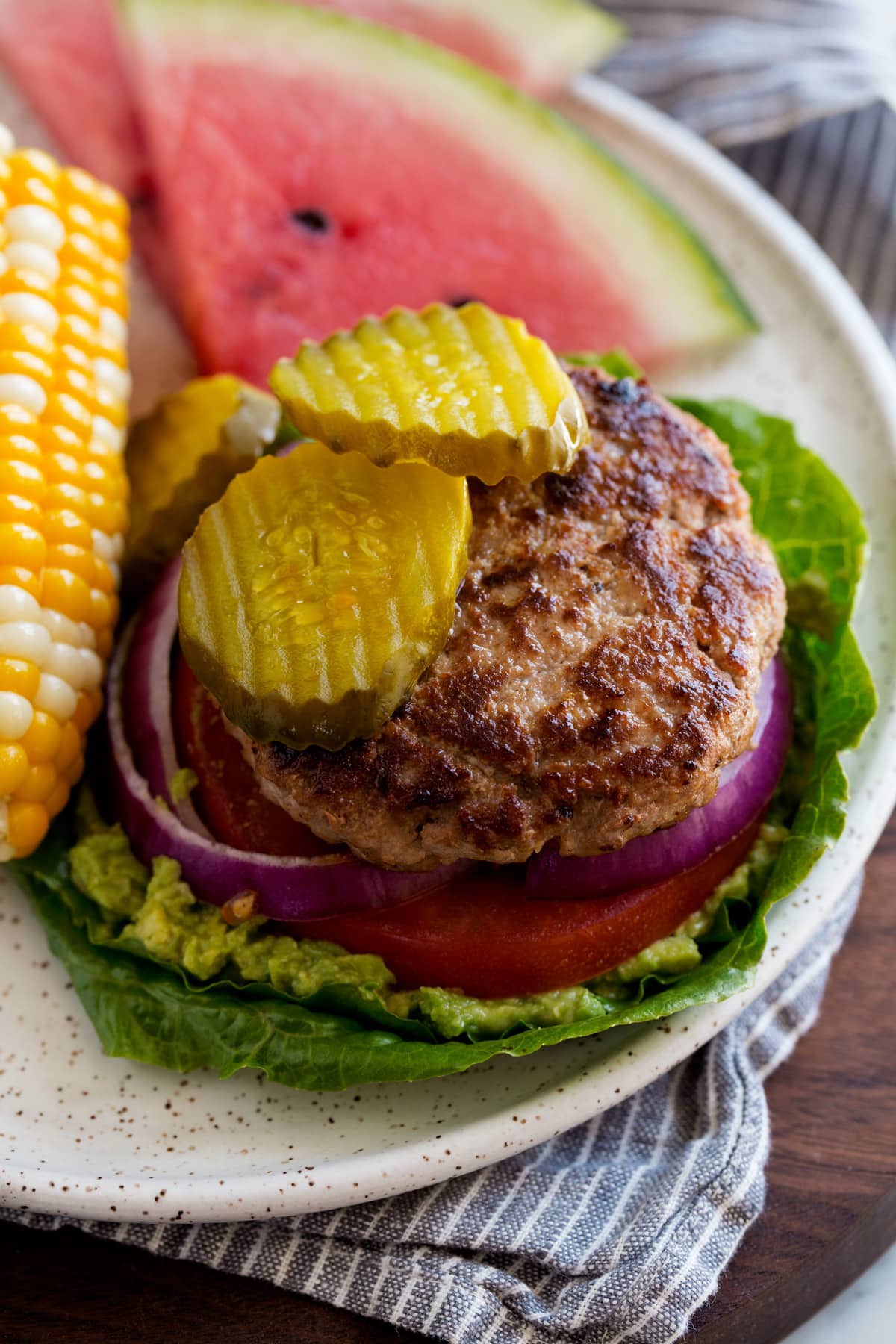 Low carb open faced turkey burger on lettuce leaves. Served with a side of corn and watermelon.