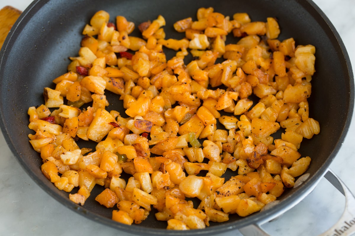 Breakfast Burritos sautéing diced potatoes in a skillet