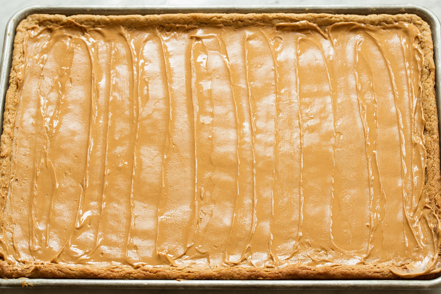 Peanut butter spread over cookie bars.
