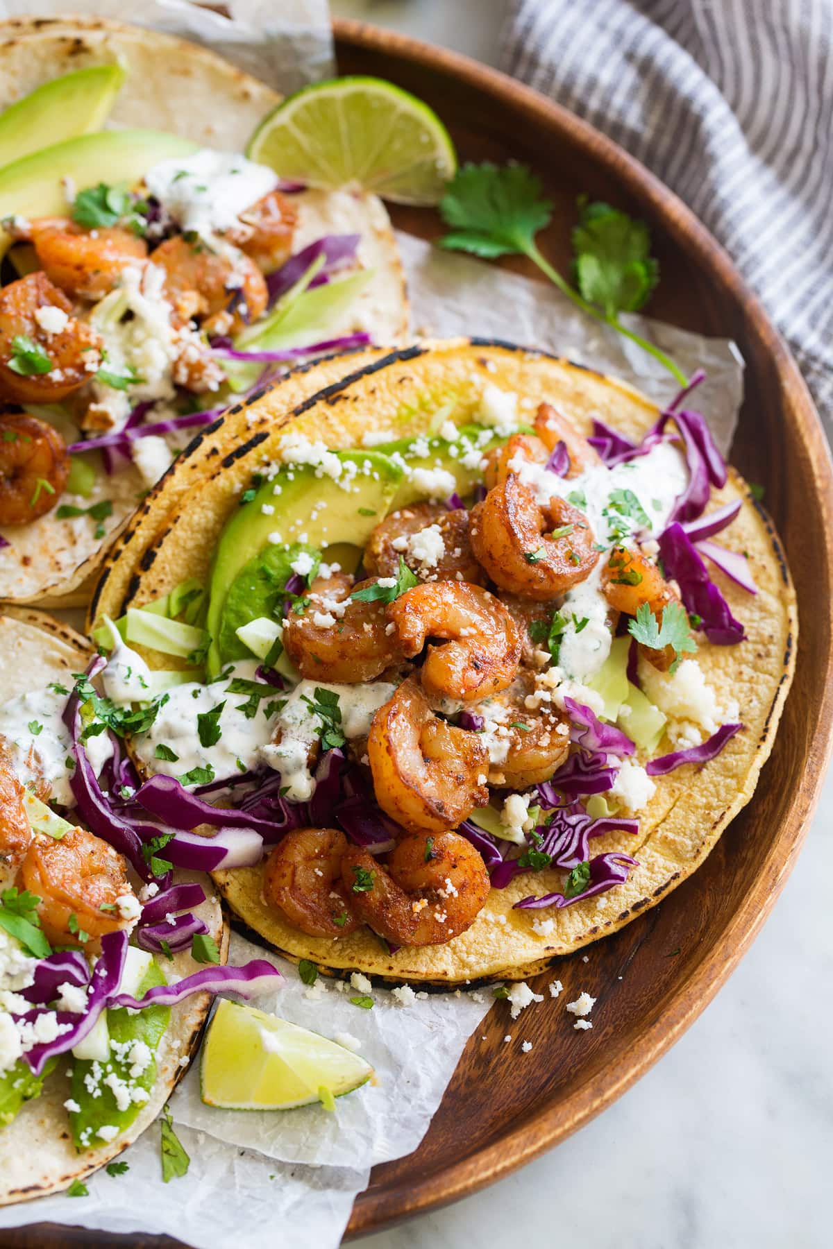 Shrimp Tacos on corn tortillas with cabbage, avocado, cheese and creamy taco sauce.