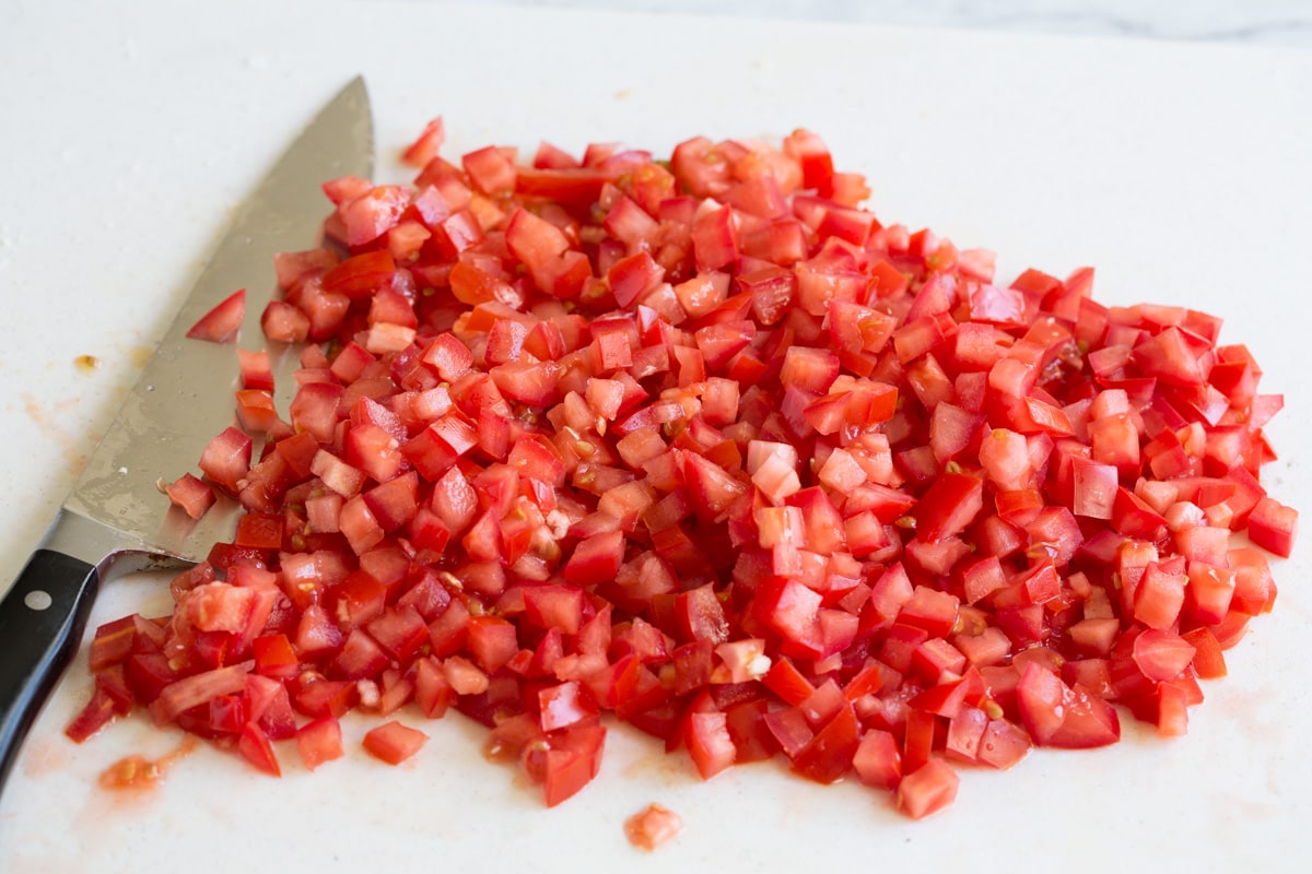 Chopped roma tomatoes on a cutting board