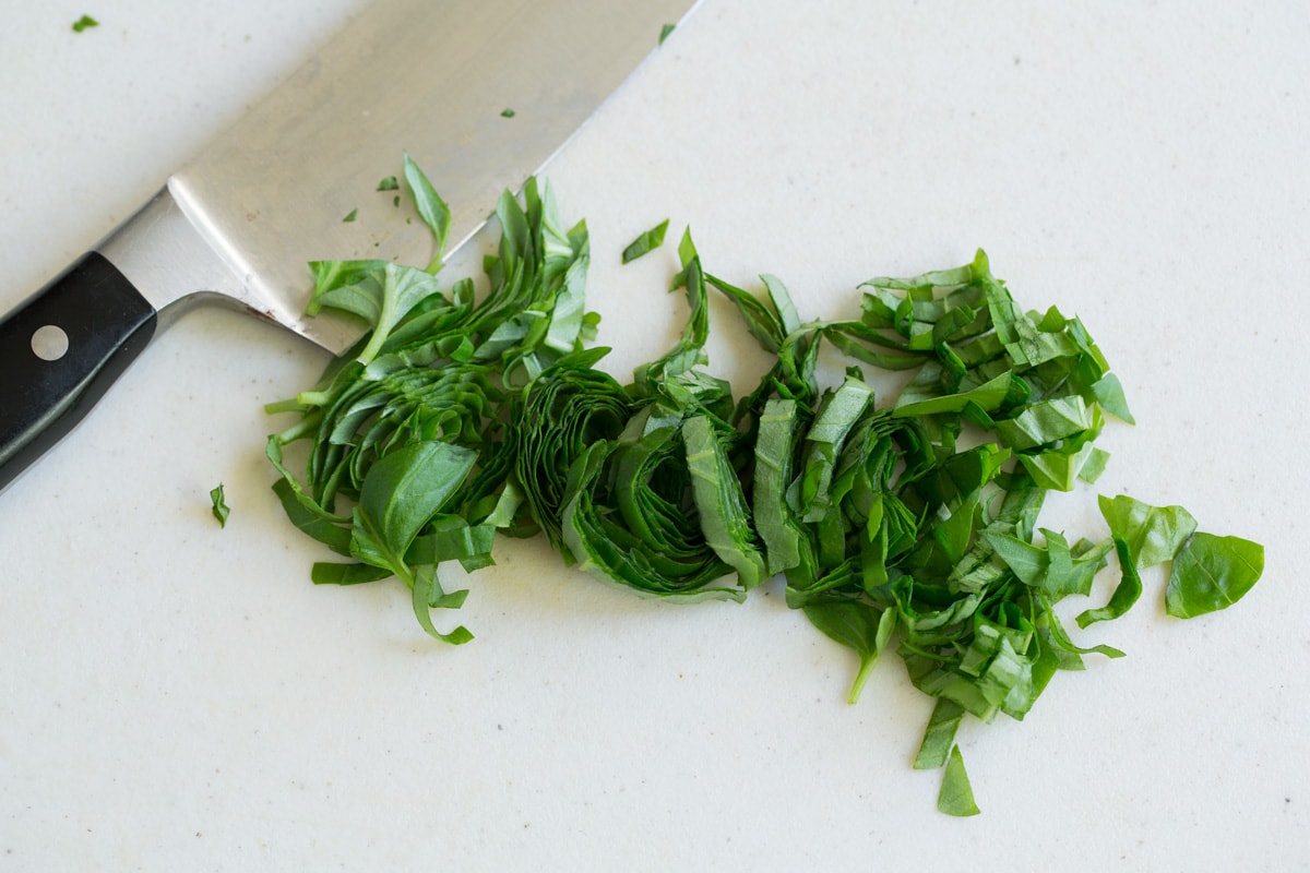 Chopped basil ribbons on a cutting board 