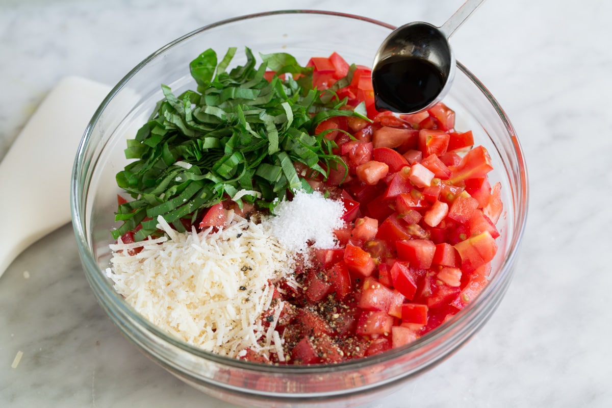 Bruschetta ingredients in a glass mixing bowl before mixing