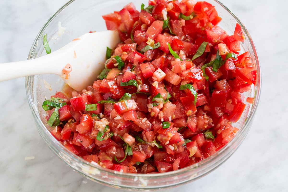 Tomato bruschetta mixture in a glass mixing bowl