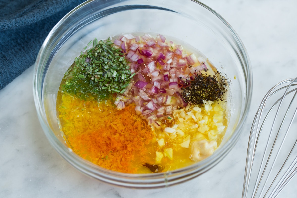 Showing how to make citrus chicken marinade. Ingredients in a glass mixing bowl with whisk to the side.