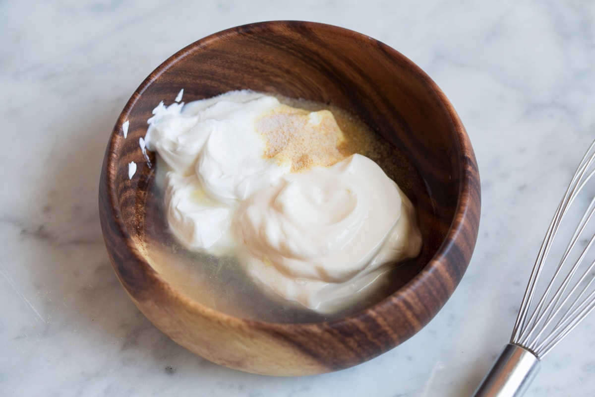 Fish taco sauce ingredients in a wooden bowl before mixing.