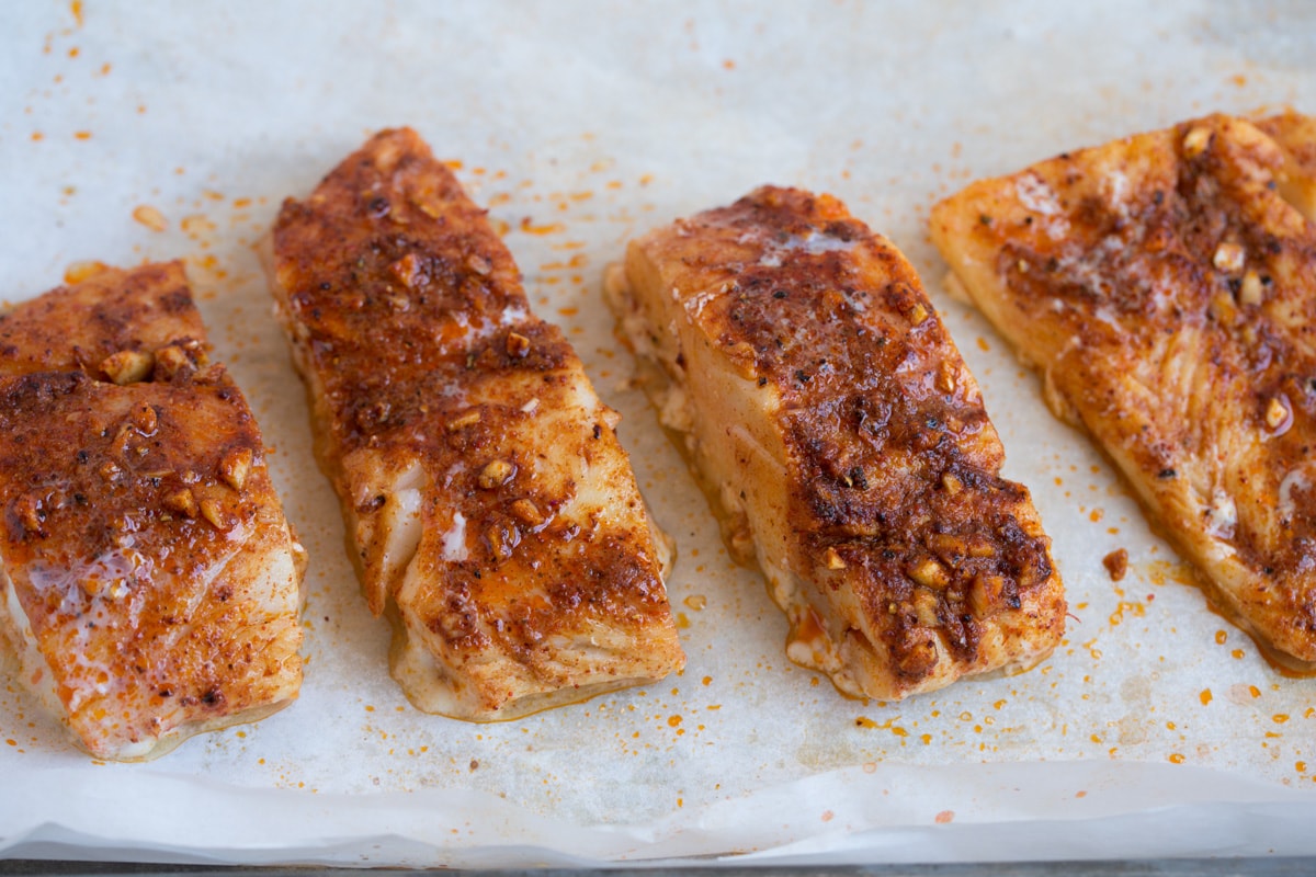 Mexican seasoned fish fillets on a baking sheet after baking.