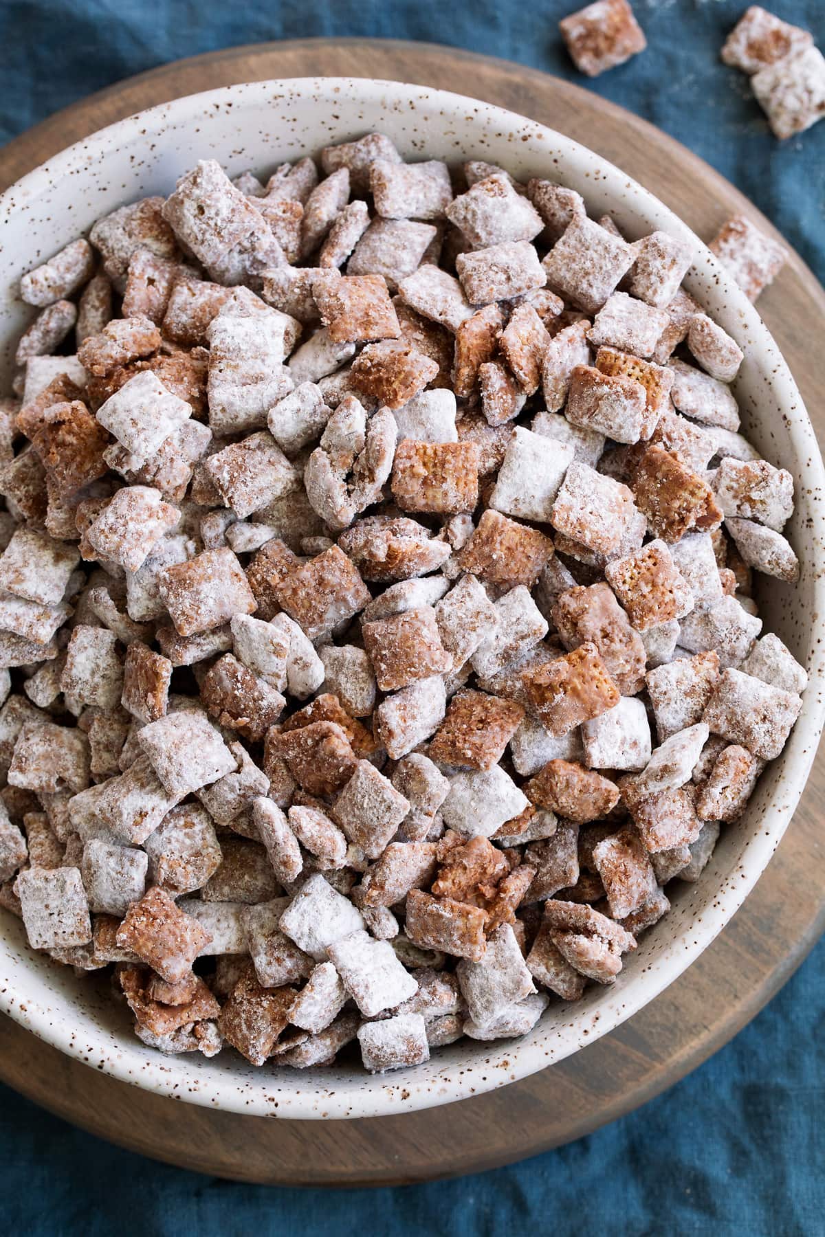 Perfect Puppy Chow {Muddy Buddies}! - one of my go-to treats! These are dangerously addictive! We love to take these on vacation, and they're perfect for parties and holidays too. #muddybuddies #puppychow #treat #chocolate #chex #peanutbutter Puppy chow muddy buddies in a serving bowl.