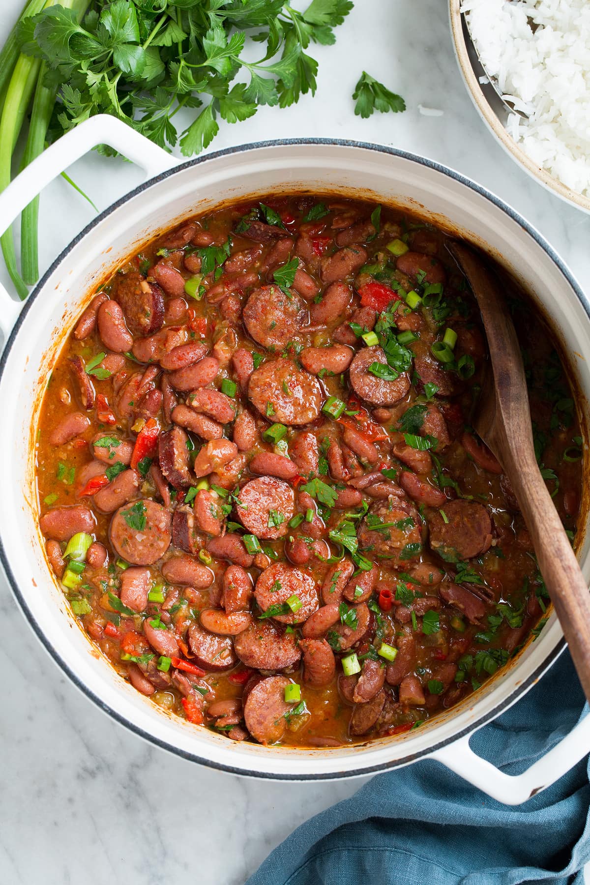 Overhead image of pot full of red beans and sausage with a side of rice on the side.