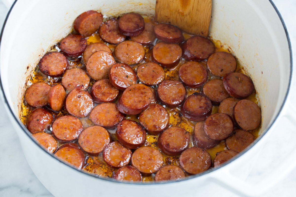 Browning smoked sausage in a pot.