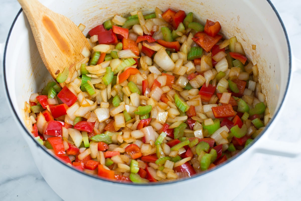 Sautéing bell pepper, celery, onion and garlic in a pot.