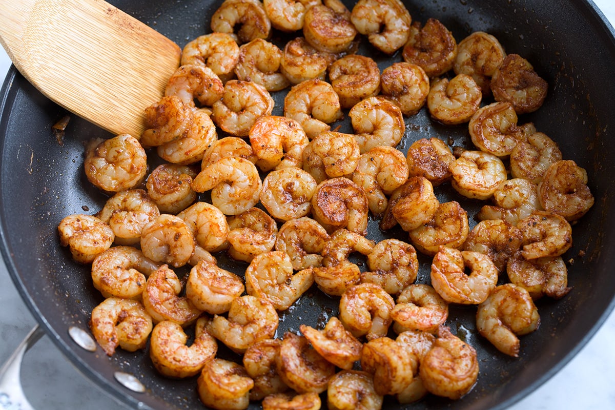 Cooking seasoned shrimp in a skillet.