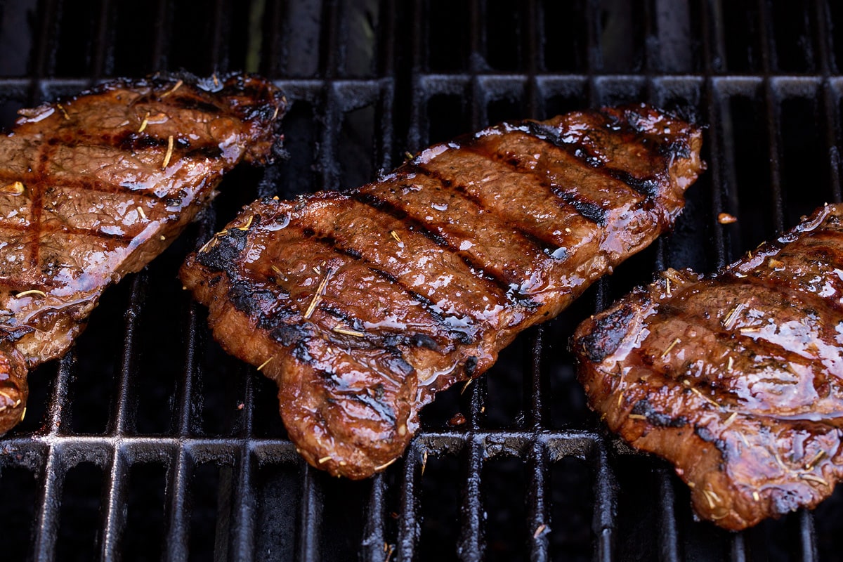 Three steaks on the grill.