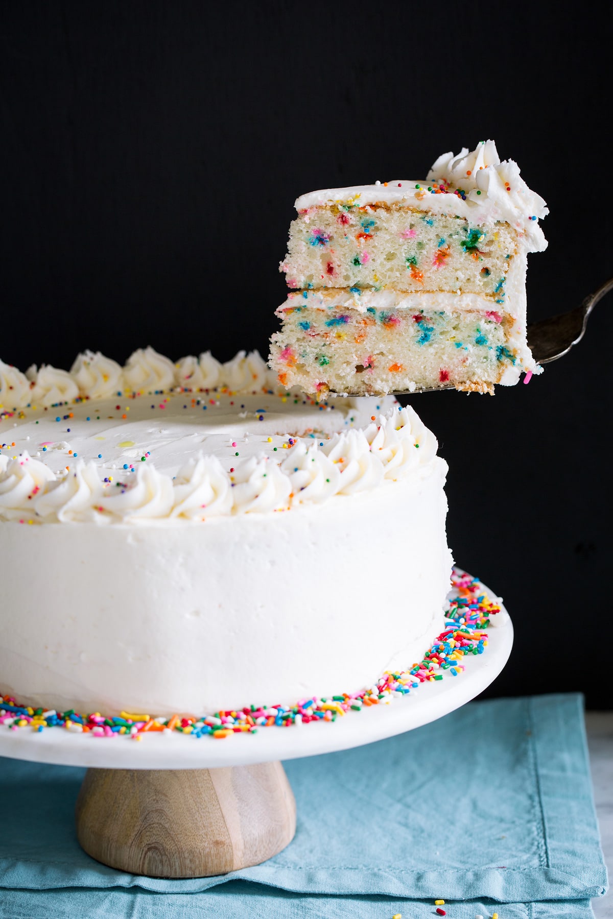 Lifting a single slice with a serving spatula from a whole cake.