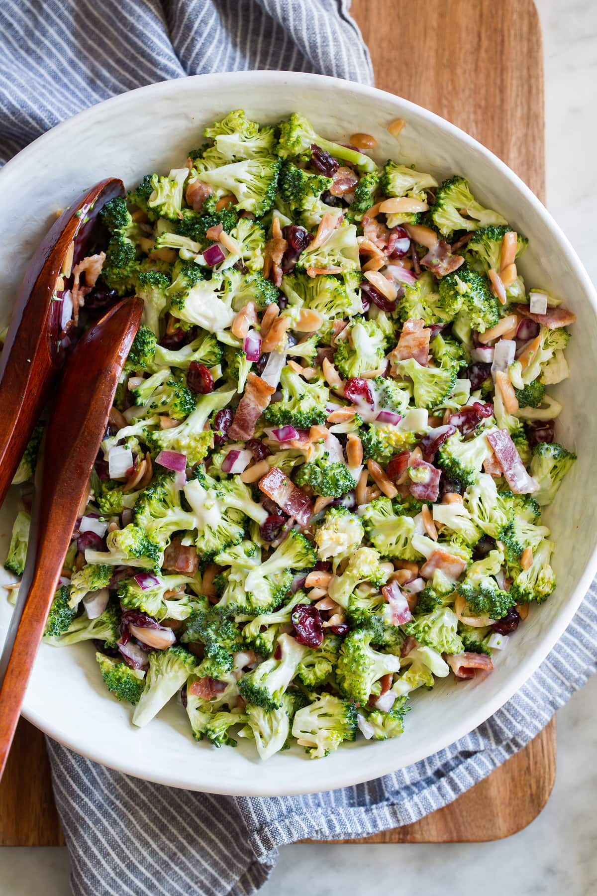 Broccoli salad in a serving bowl with serving spoons.