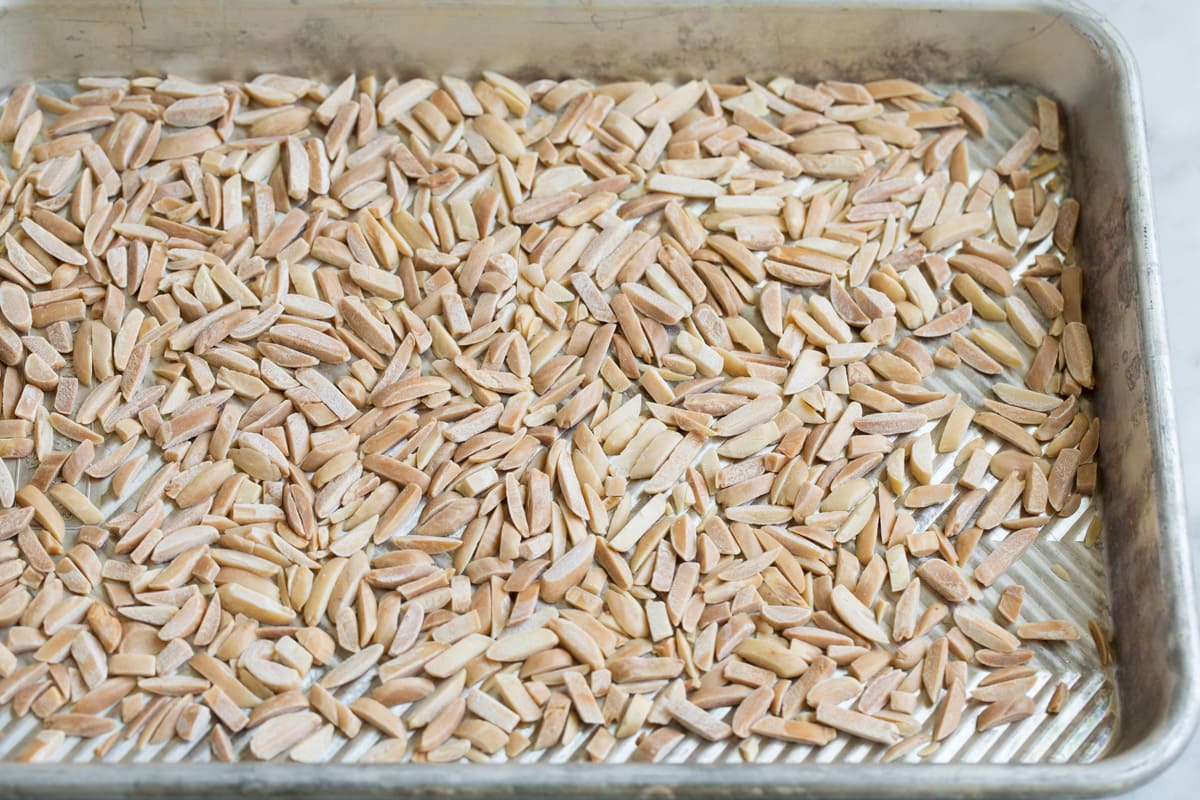 Toasted slivered almonds on a baking sheet.