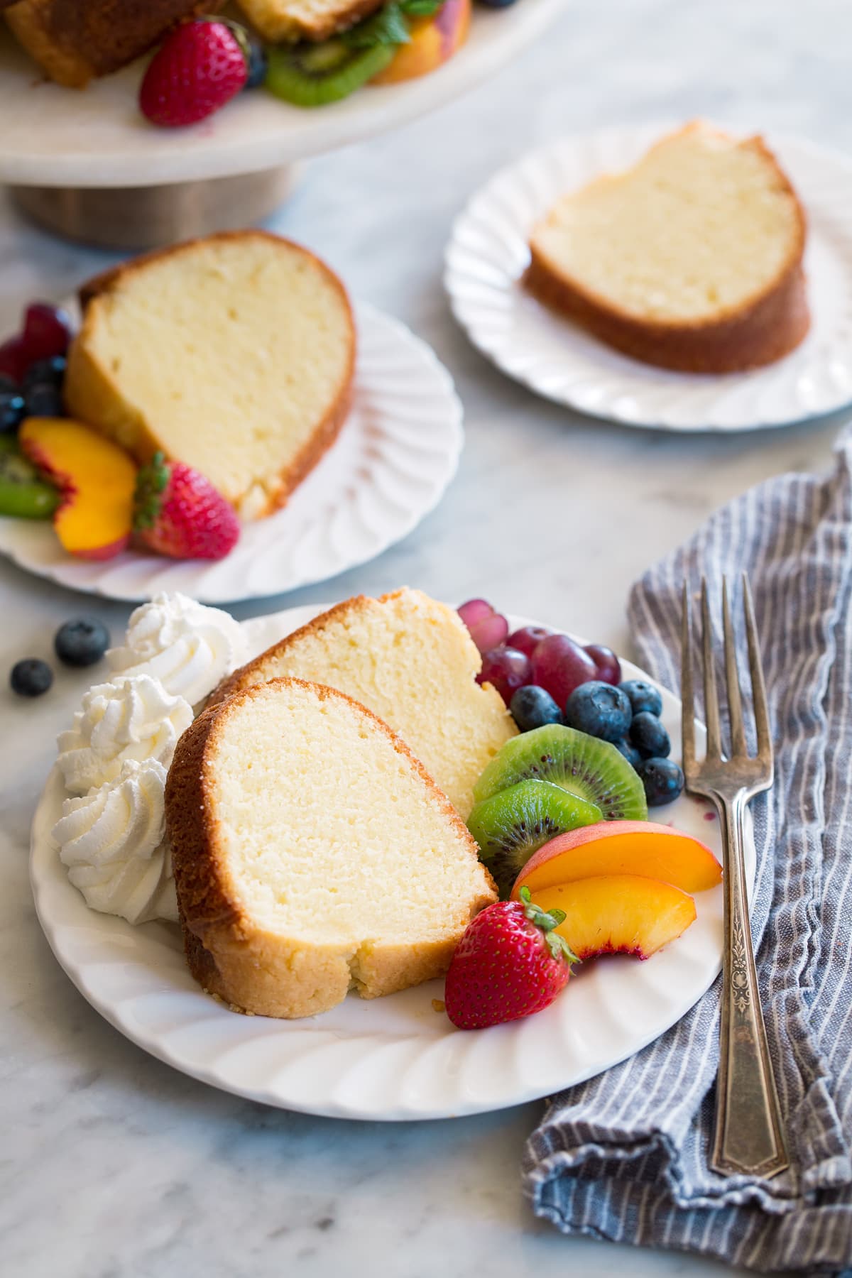 Three white dessert plates with slices of homemade pound cake.