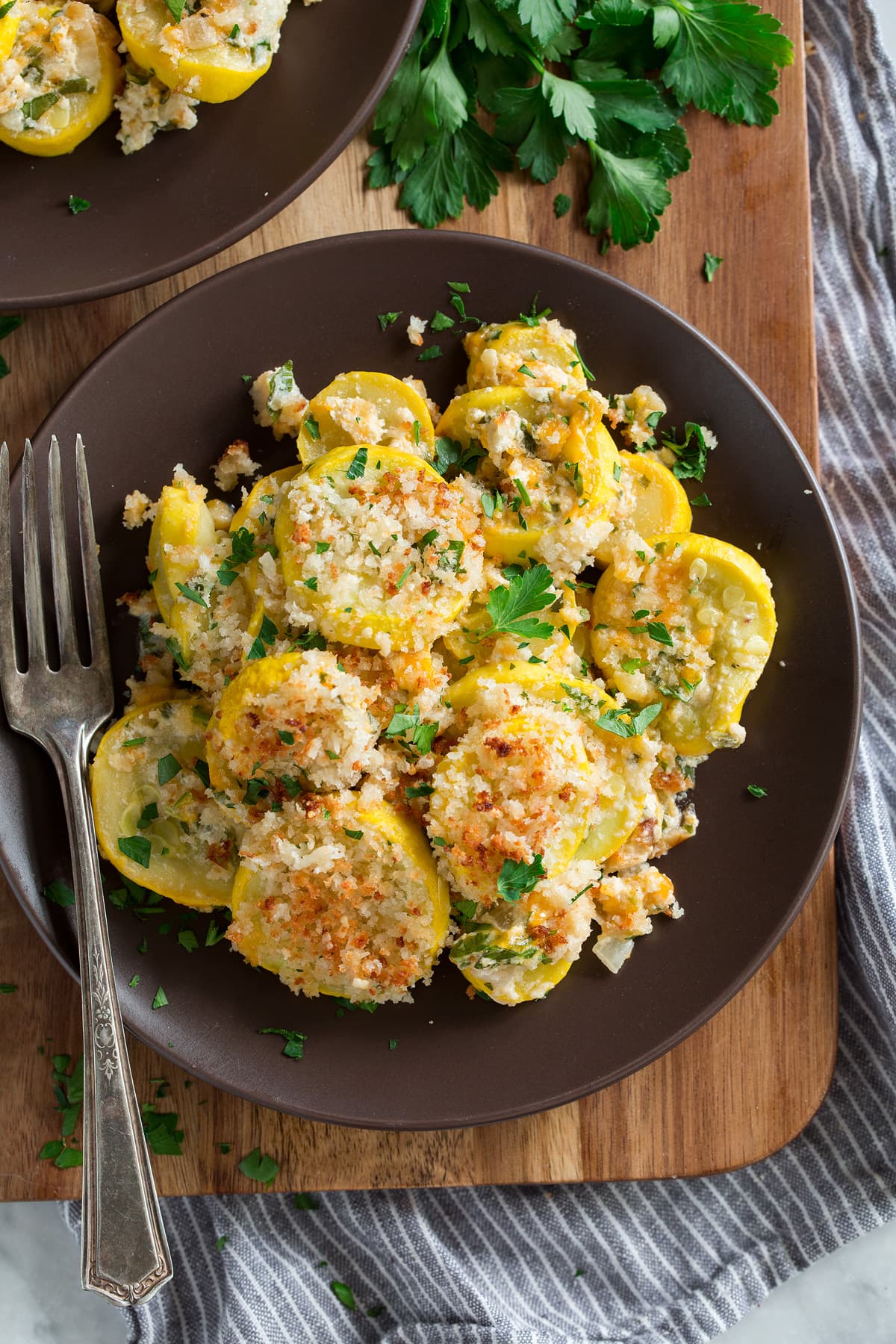 Cheesy squash casserole on a brown plate.