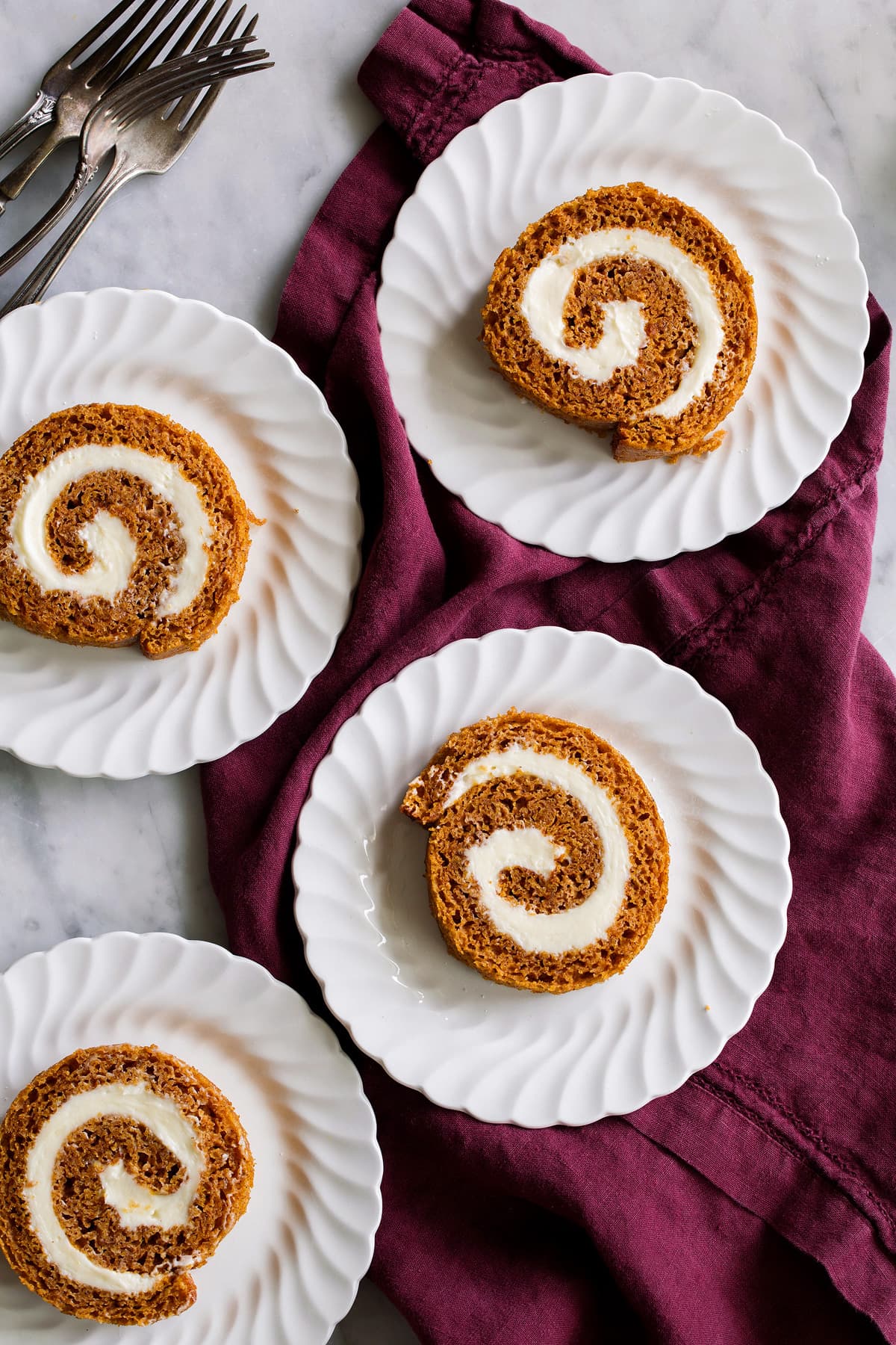 Four slices of pumpkin roll on a dessert plate.