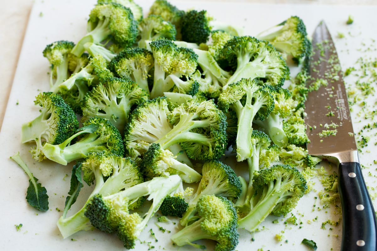 perfectly tender, deliciously browned and incredibly flavor. Broccoli goes from drab and bland to perfectly flavorful with this simple method. The best way to cook broccoli! Cutting broccoli florets from stem on a cutting board.