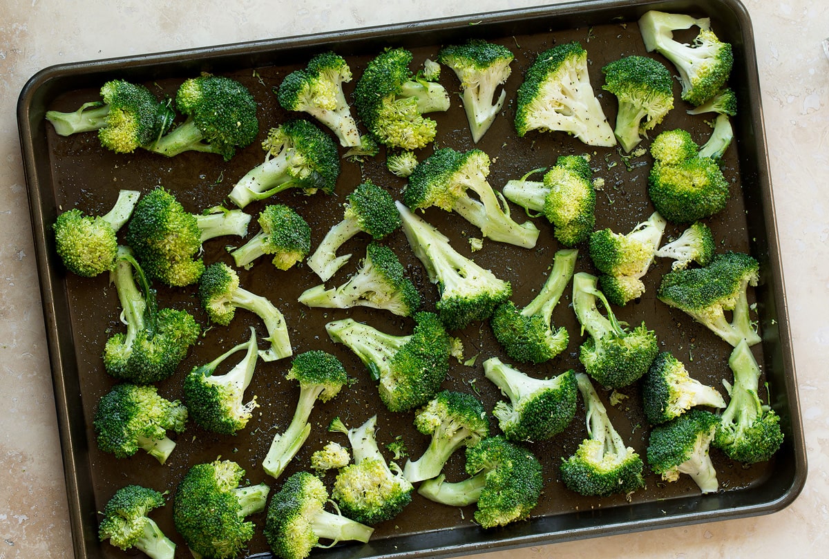perfectly tender, deliciously browned and incredibly flavor. Broccoli goes from drab and bland to perfectly flavorful with this simple method. The best way to cook broccoli! Raw boccoli florets on a baking sheet before baking.