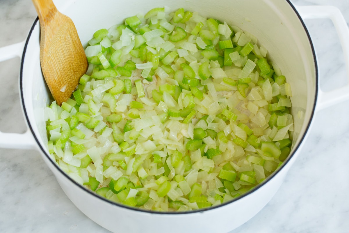Showing how to make split pea soup. Sauteing celery and onion in pot.