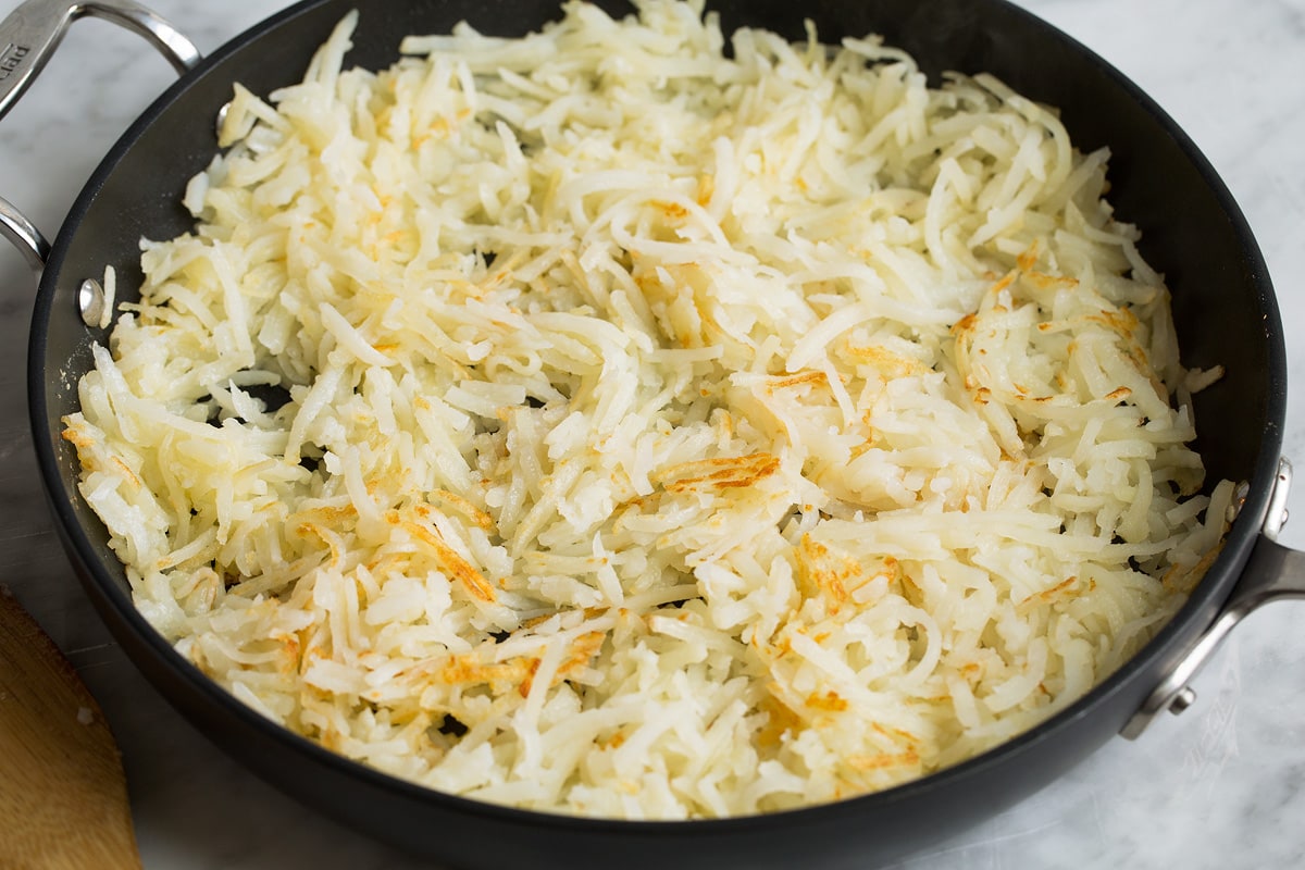 Sautéed hash browns in a large skillet.